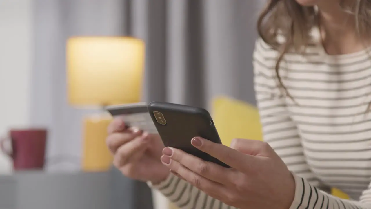 Close Up Of Woman At Home Shopping Online With Credit Card Using Mobile Phone 2