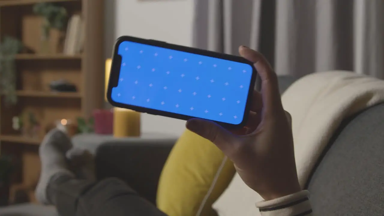 Close Up Of Excited Woman At Home Watching Sports Or Film Onto green screen blue Screen Mobile Phone 