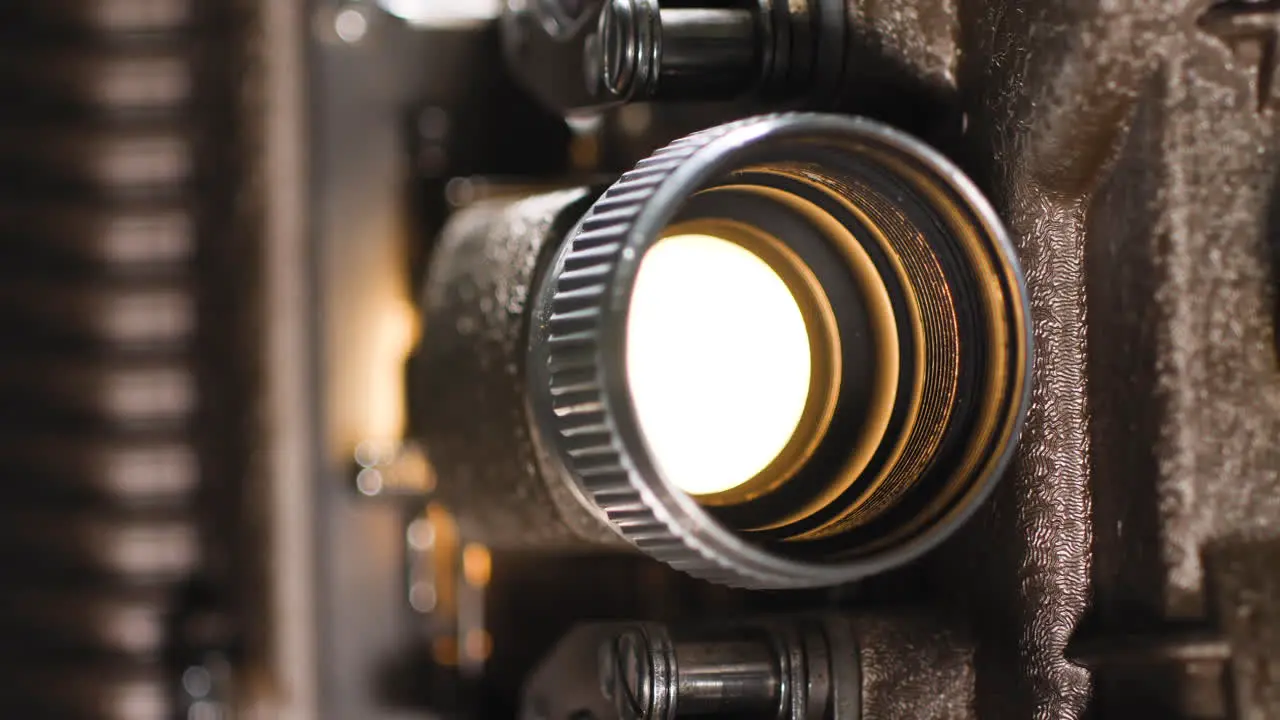 Macro close up of an old vintage analog 8mm projector light bulb playing an 8mm film reel