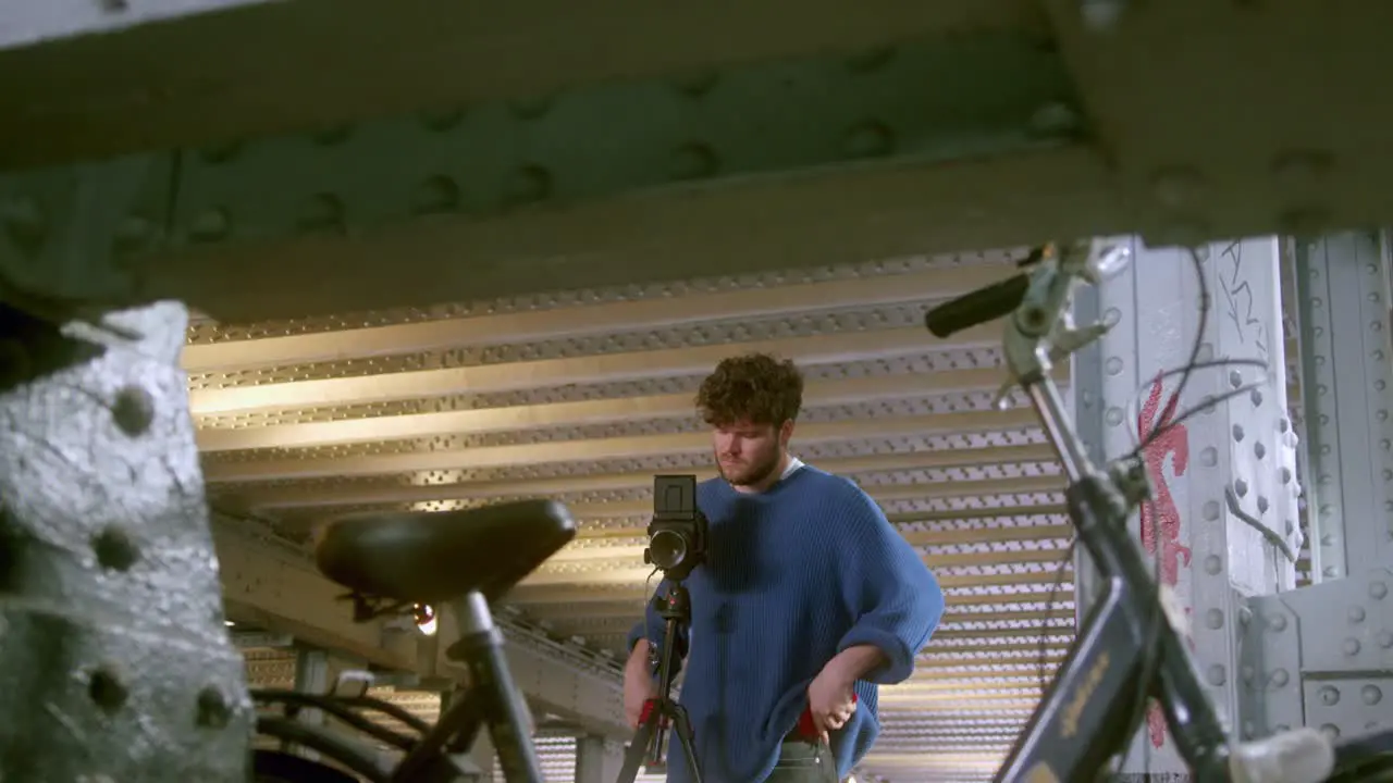 Man Setting An Analog Film Camera Indoors wide