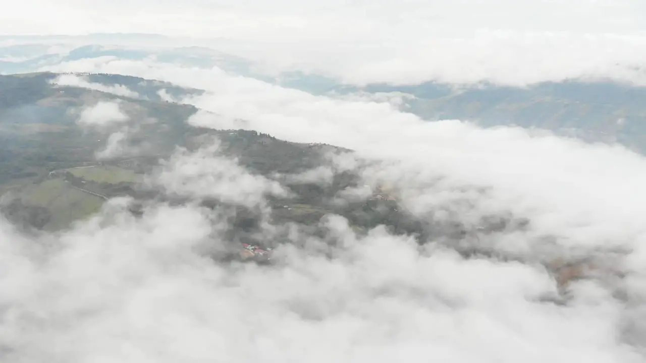 Pull lateral with drone above clouds in a misty sunrise in Colombia