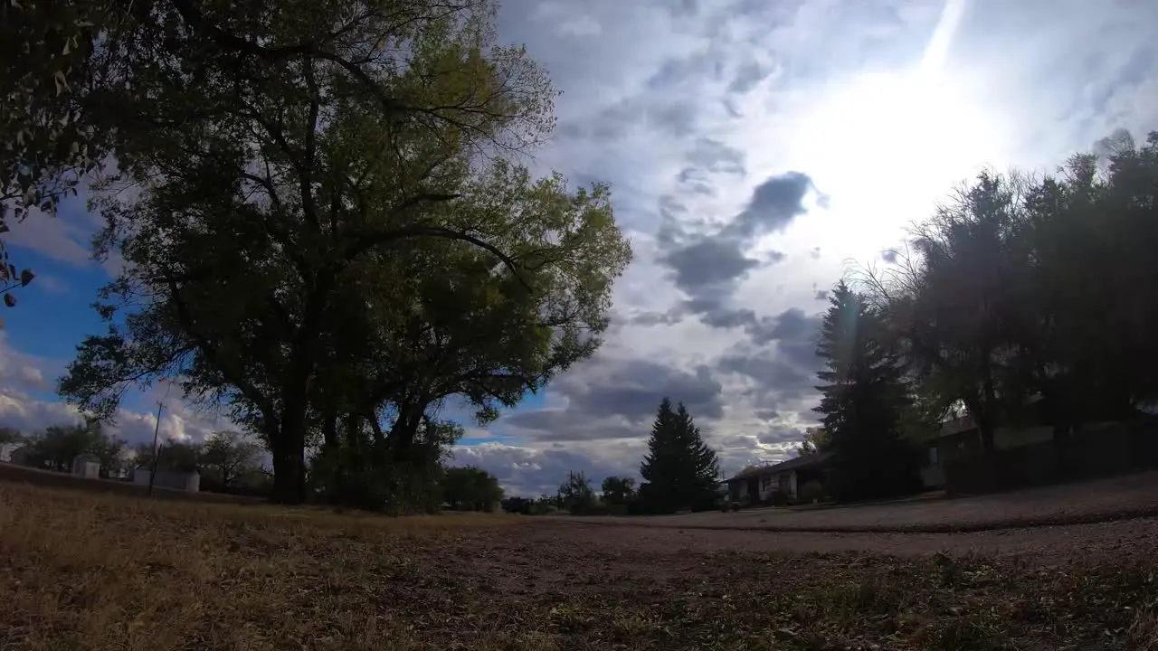 TIMELAPSE Clouds traveling in front of the sun with a view of an empty street in a small town near Alberta Canada on a nice day