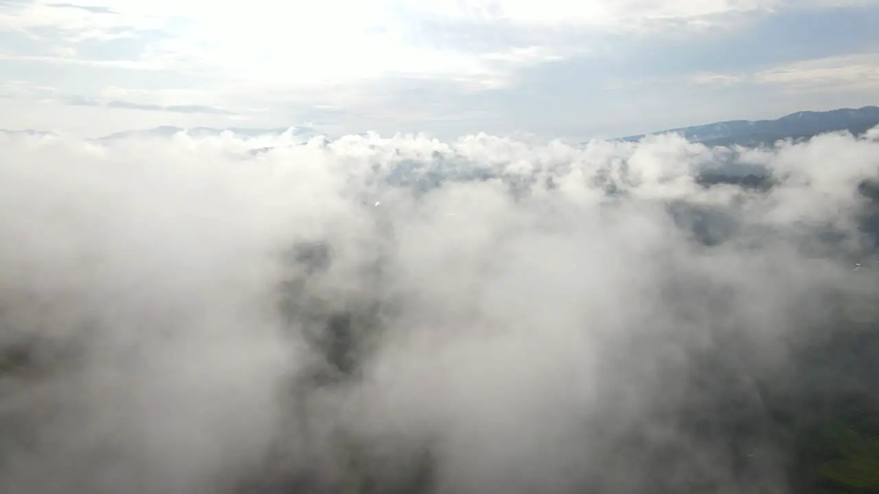 Flight over low clouds scenic view over skyscape aerial pull-away reveal