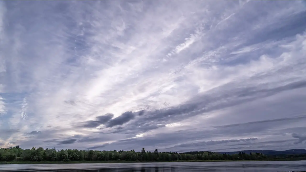 Gray clouds torn by strong wind fly above the Namsen river