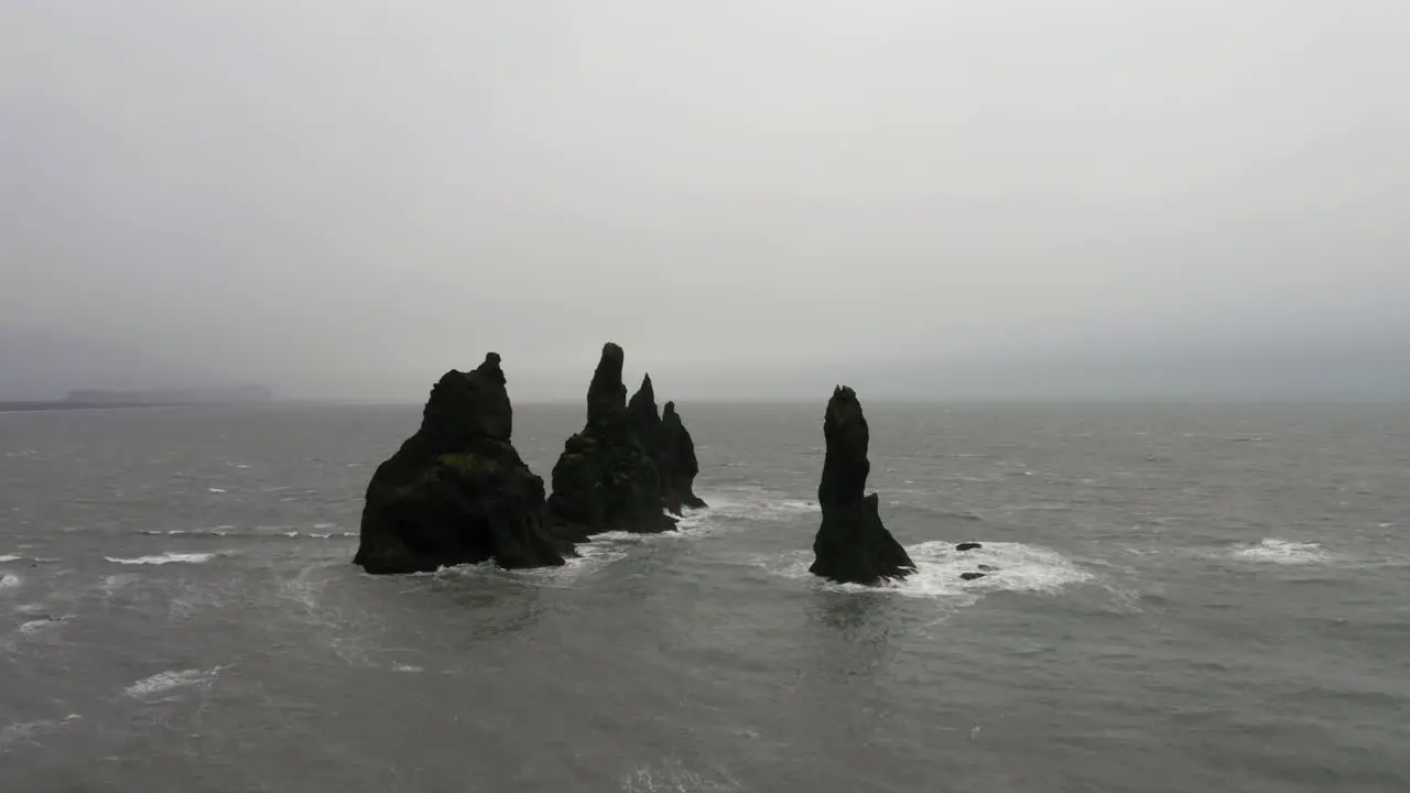 Aerial Orbit shot of Reynisdrangar Rocks in a stormy sea