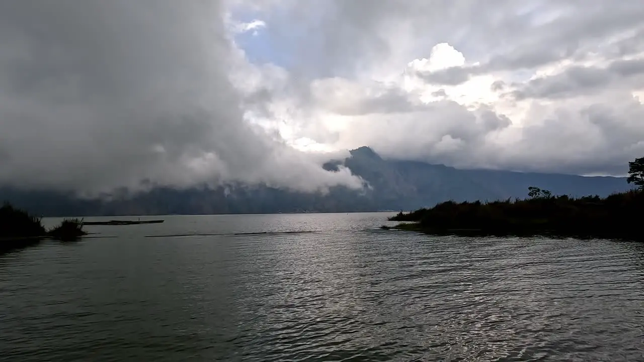 Vapor clouds rolling over lake in Kintamani Bali in evening dusk