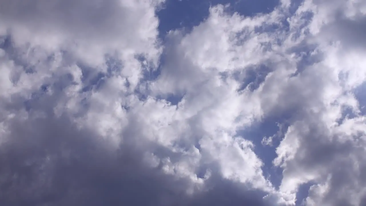 Clouds passing by from left to right with a blue sky in the background