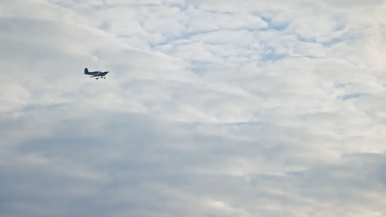 single-engine small airplane crossing the cloudy sky slowmotion