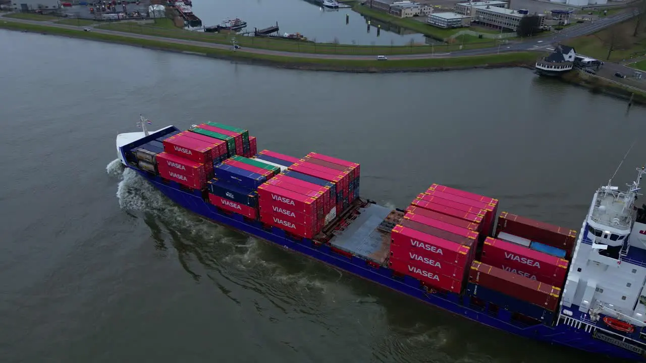 Aerial Flying Overhead Energy Cargo Ship Carrying Viasea Intermodal Containers Passing Along Oude Maas