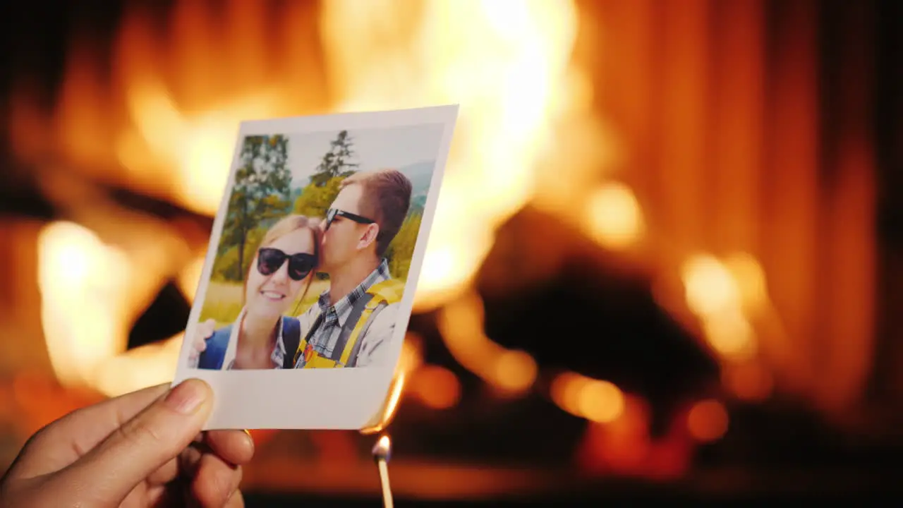 A Man Burns A Photo Of A Couple In Love And Throws It Into The Fireplace