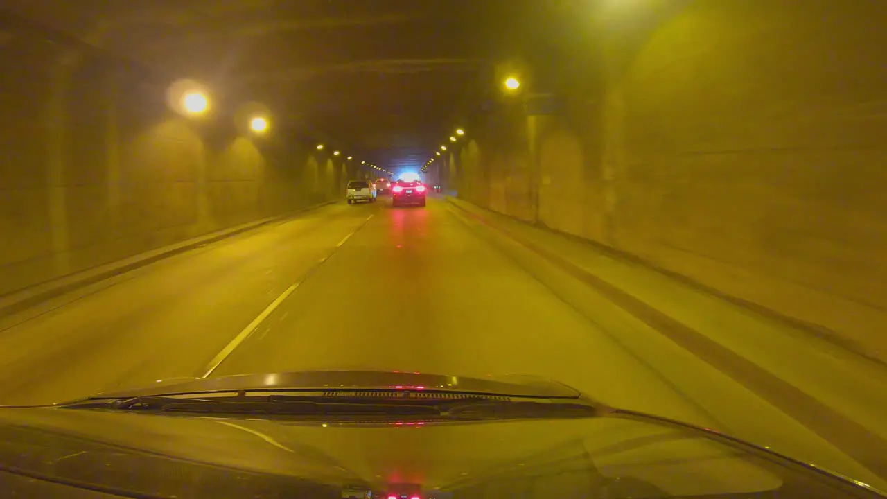 Car drives through a lighted tunnel