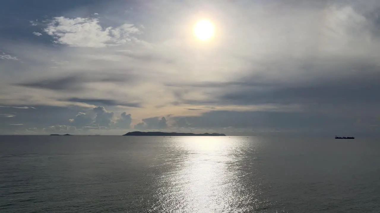 Aerial view of low setting sun reflecting on calm sea