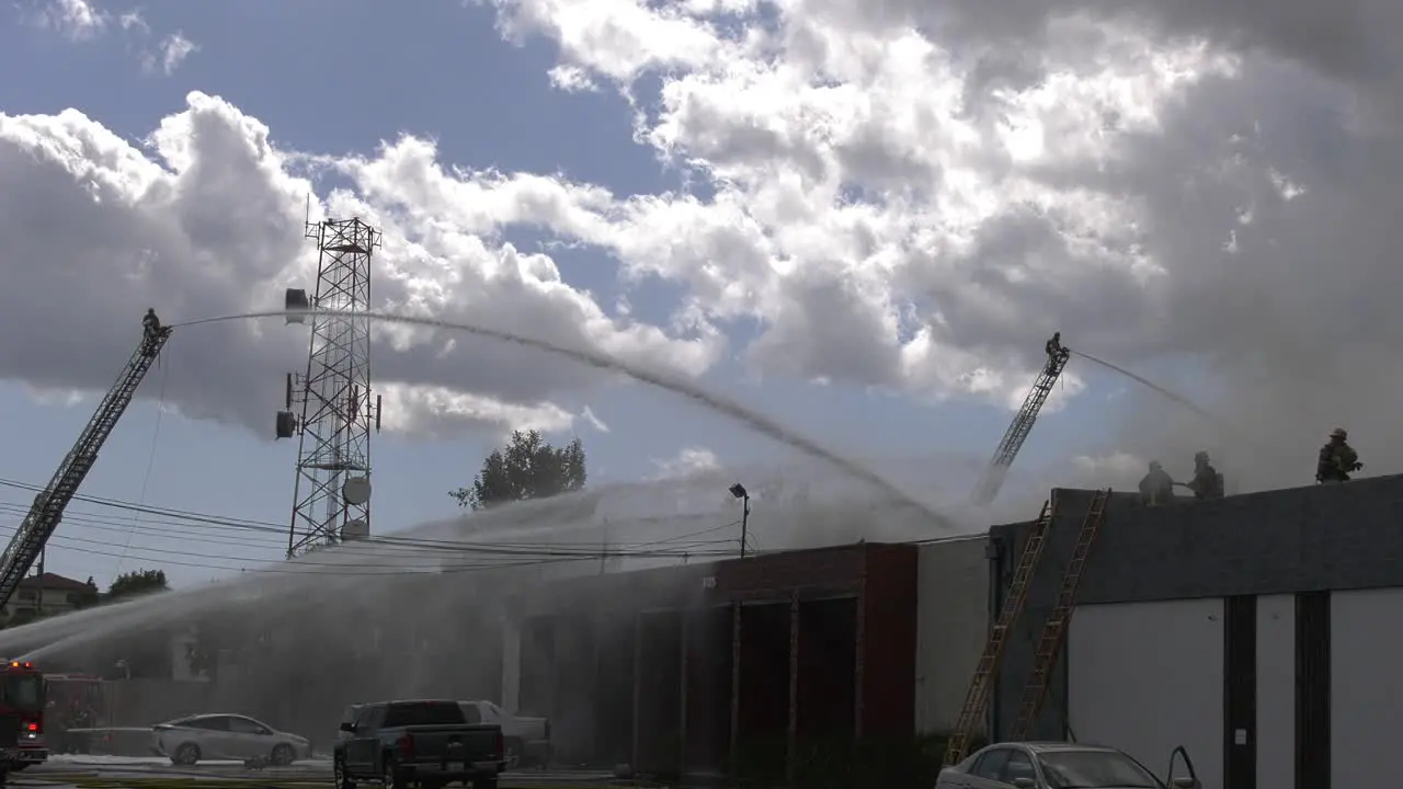 firefighters spray building with water