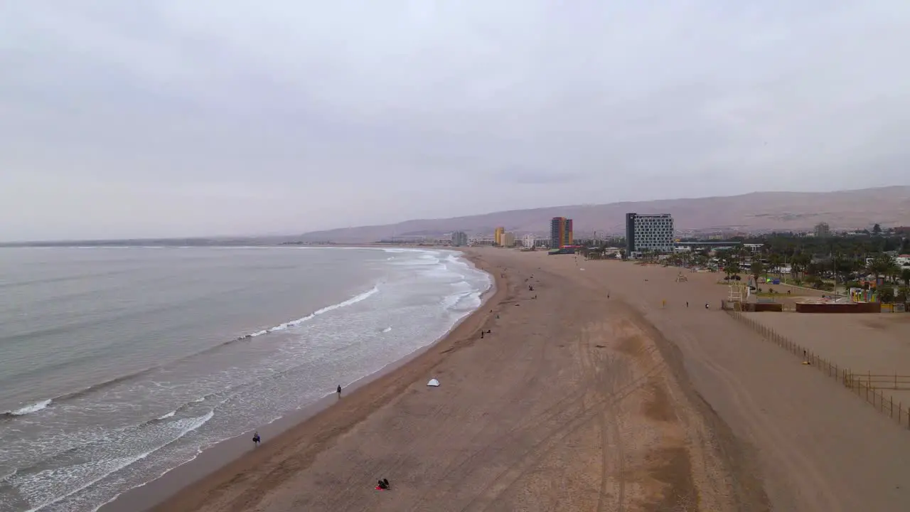 Drone shot flying along the beach in Arica Chile on a cloudy day