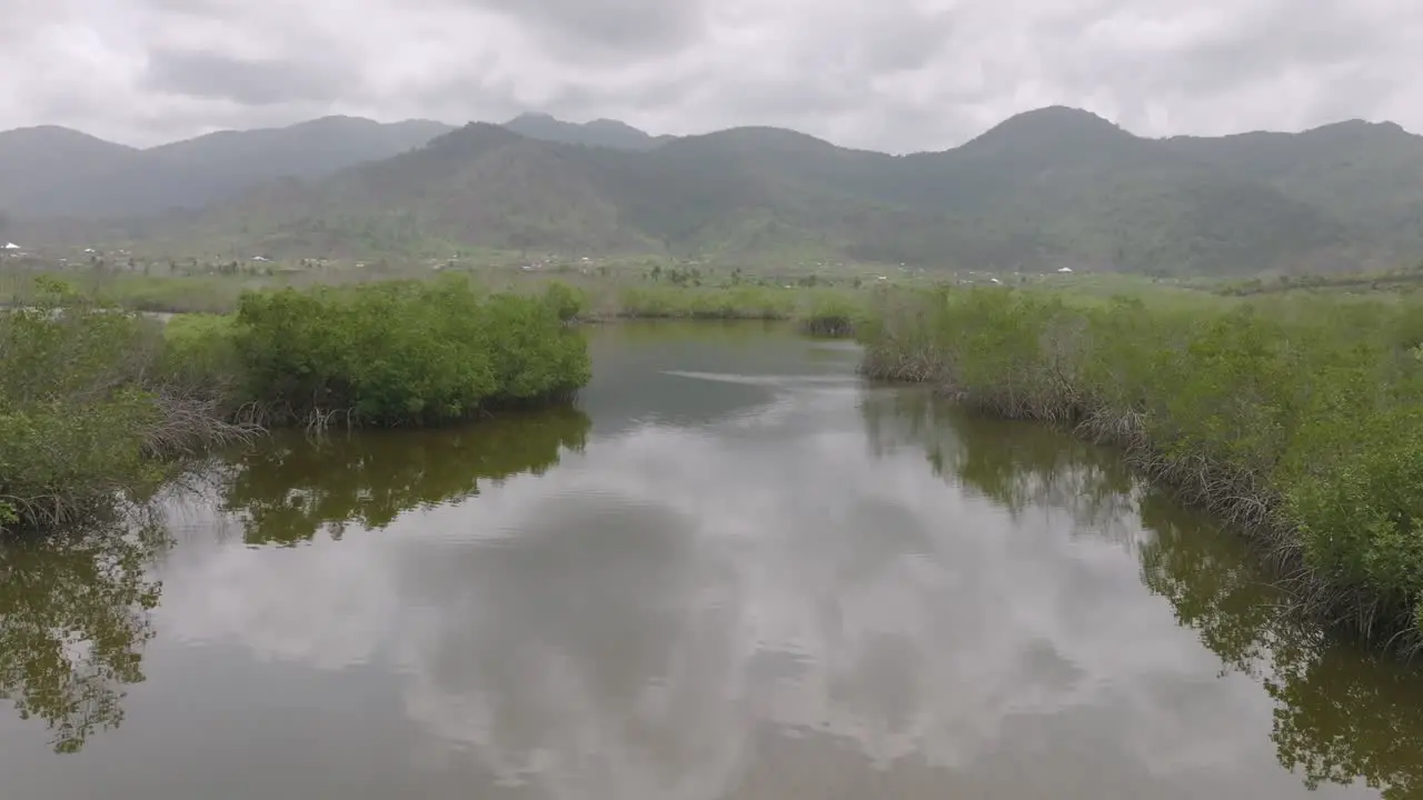 Aerial flyover of a river that is going to the ocean with mountains in the background in Sierra Leone Africa