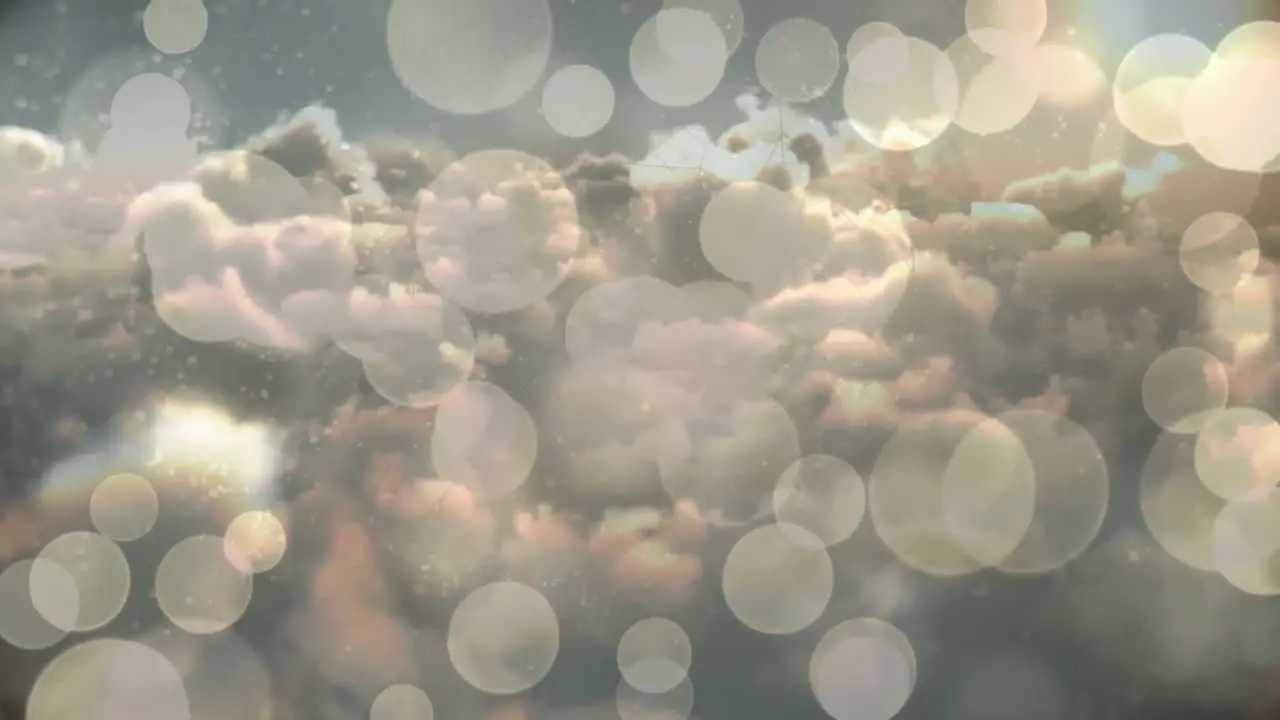 Animation of white bokeh spots of christmas lights over cloudy sky