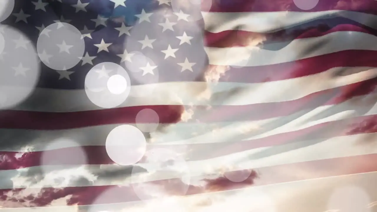 Animation of waving usa flag and glowing spots over cloudy sky