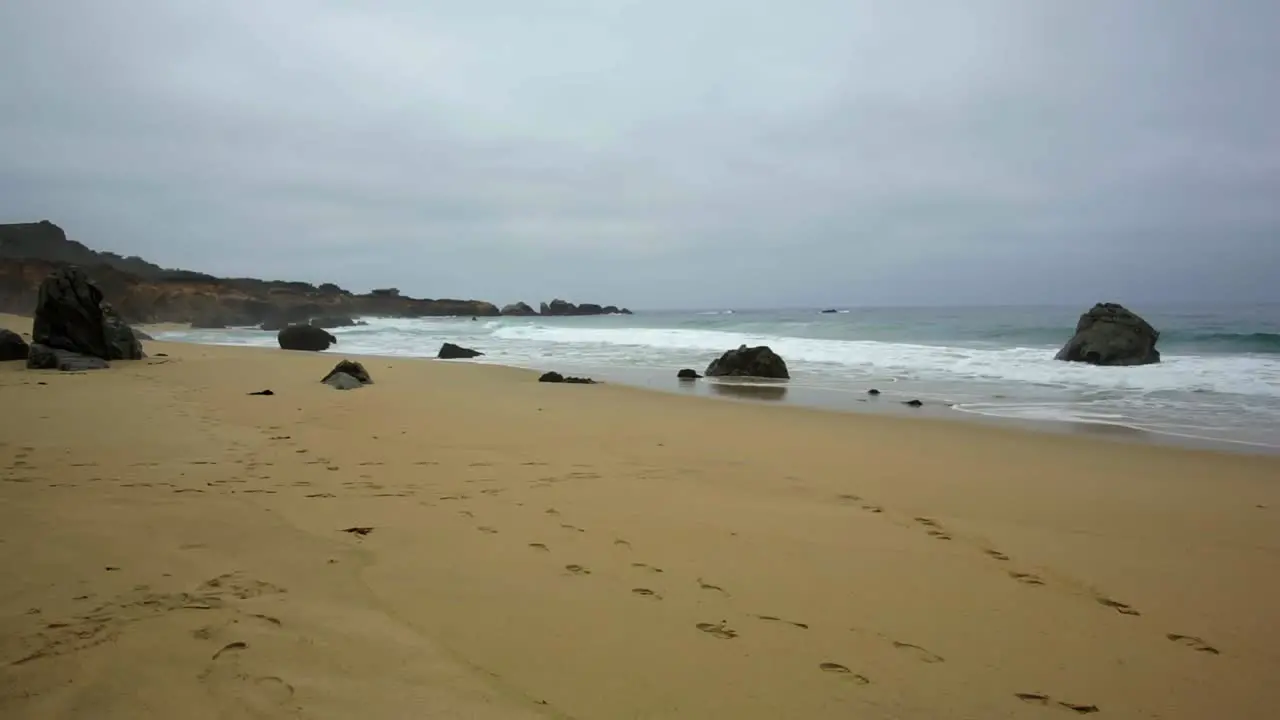 Waves on sandy cloudy Big Sur Garrapata Beach