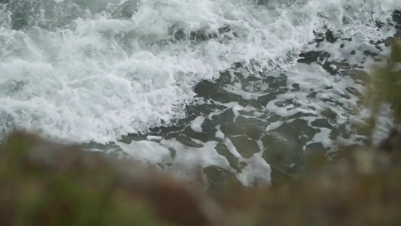 Incoming beautiful wave with blurry rock in the foreground