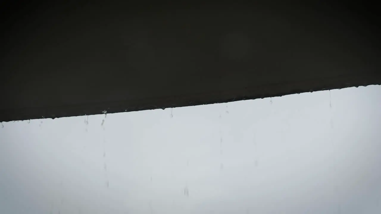 Rain drops fall off of roof in slow motion