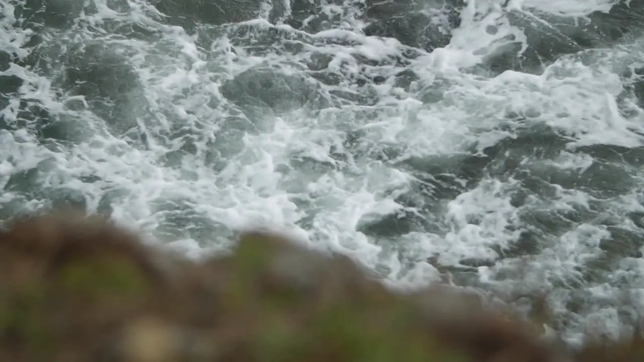 Turbulent sea waters with rock in the foreground