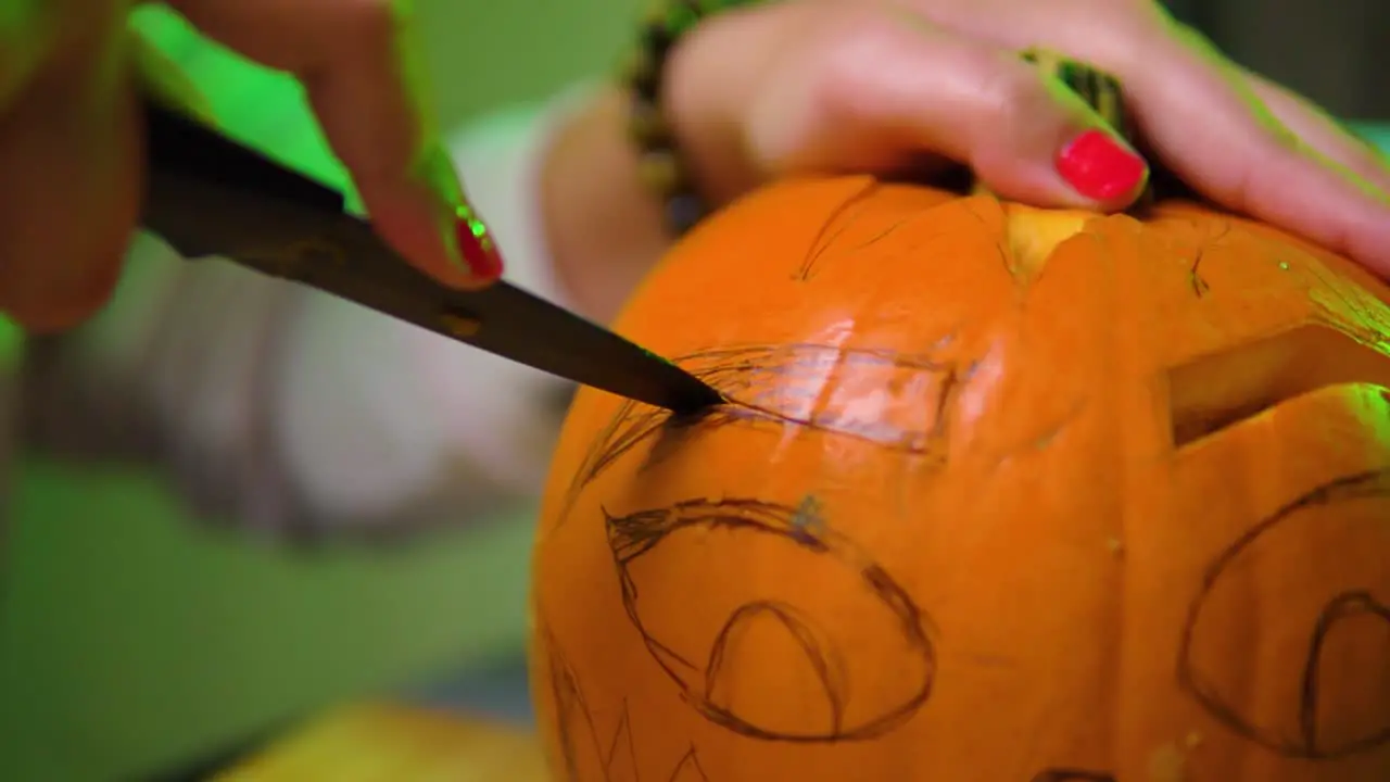 Extreme close up of cutting eyebrow shape out of the pumpkin in slowmotion