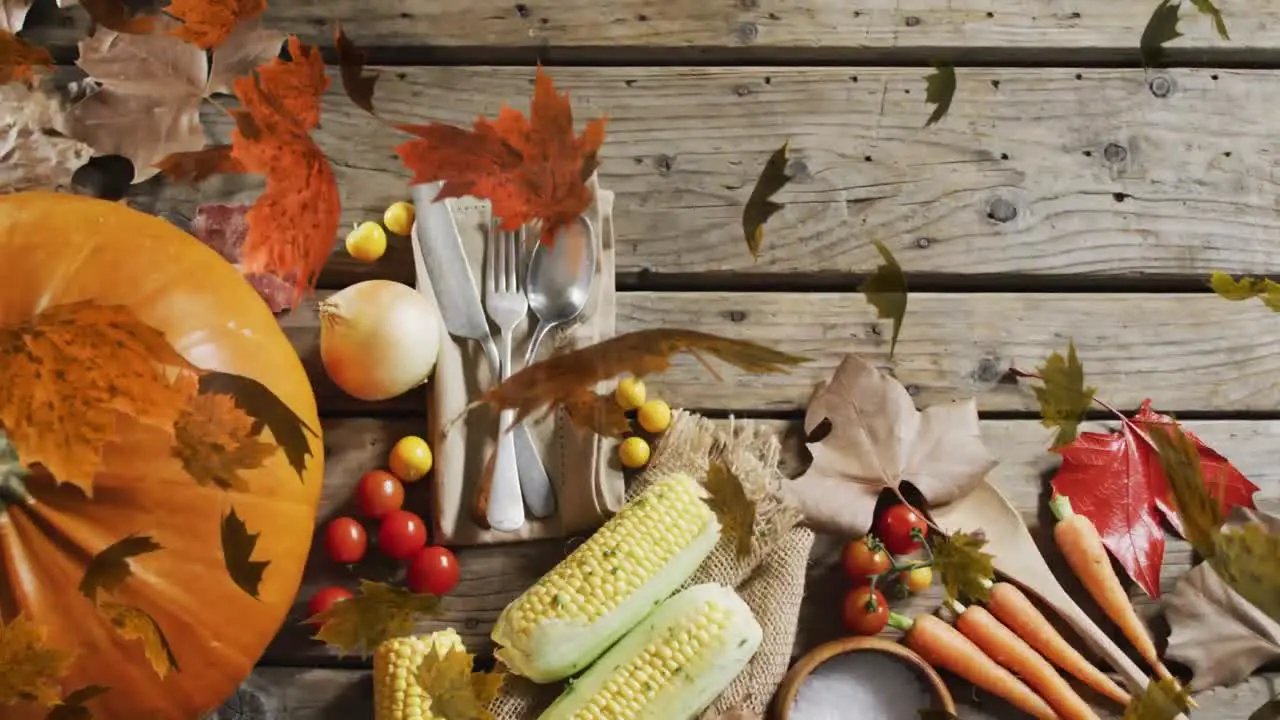 Animation of halloween pumpkin leaves and autumn produce on wooden background