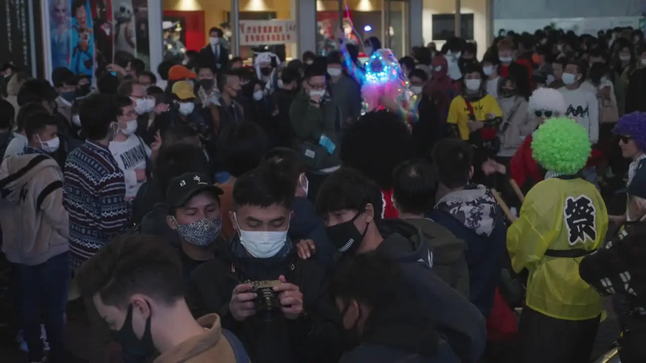 Crowd In Masks And Costumes Enjoying The Event Outside The Shibuya Station On Halloween Night 2020 Amid The Coronavirus Pandemic Medium Shot