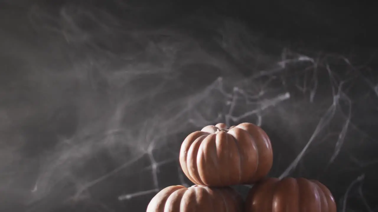 Video of halloween pumpkins and smoke with copy space on grey background