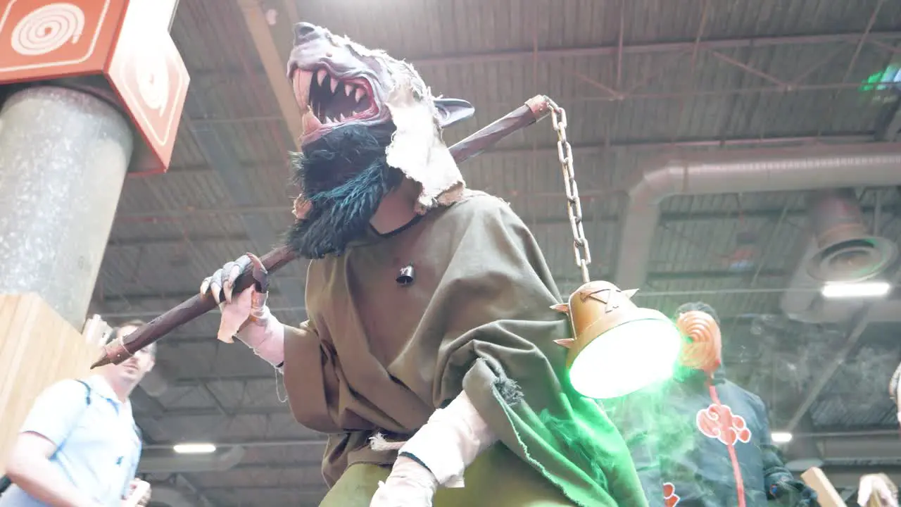 Person dressed up as rat-man at japan expo in paris France while tourists walk through the event