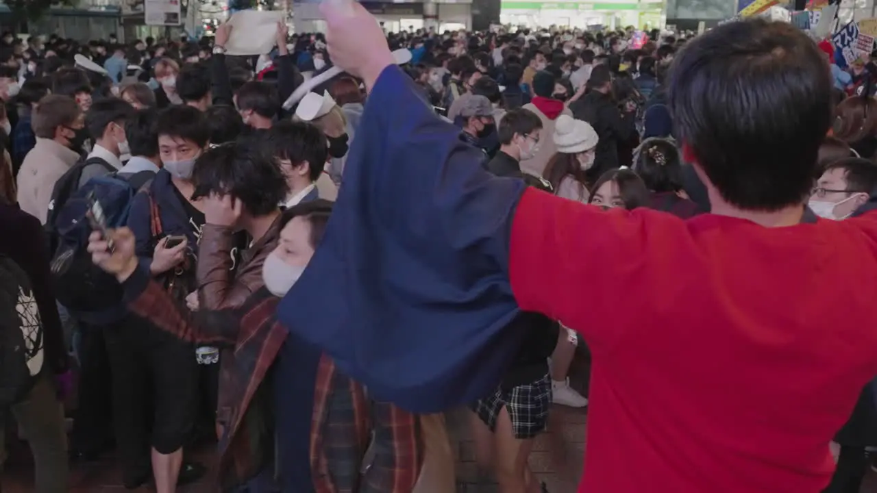 A Guy In Red Shirt With Ruffles Not Wearing Mask Performing In Front Of The Busy Crowd On Halloween Night At Shibuya Crossing In Tokyo Japan Slow Motion