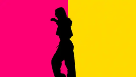 Studio Silhouette Of Woman Dancing Against Yellow And Pink Backgrounds