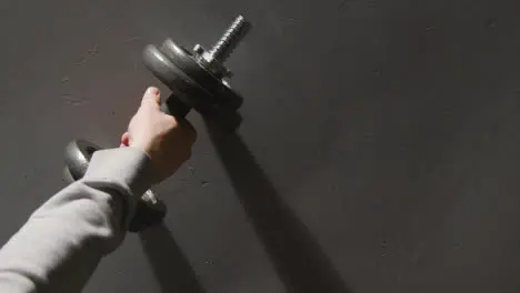 Overhead Studio Fitness Shot Of Hand Picking Up Gym Weight On Grey Background 2