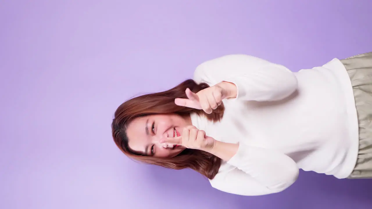 Asian Woman Cheerful and Having Fun Pointing Fingers at Camera