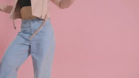 Close Up On Legs Of Woman Having Fun Dancing Against Pink Studio Background