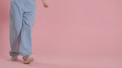 Close Up On Legs And Feet Of Woman Having Fun Dancing Against Pink Studio Background 1