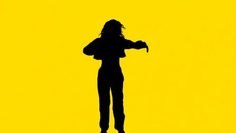 Studio Silhouette Of Woman Dancing Against Yellow Background