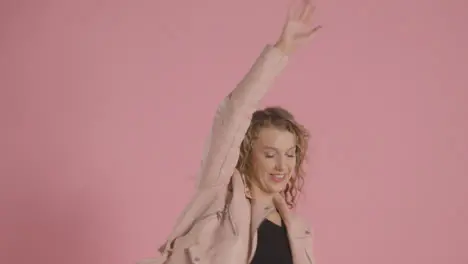 Studio Shot Of Young Woman Having Fun Dancing Against Pink Background 3