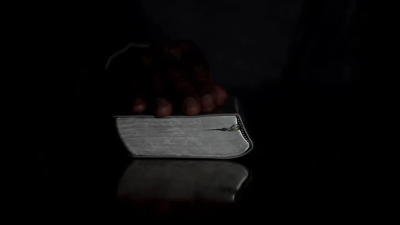 praying to god with hands together with bible black man praying with black background stock video stock footage