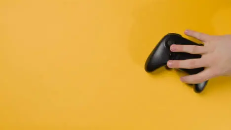 Overhead Studio Shot Of Hand Reaching In To Pick Up Video Game Controller 7