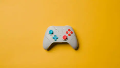 Overhead Studio Shot Of Hand Reaching In To Pick Up Video Game Controller 8