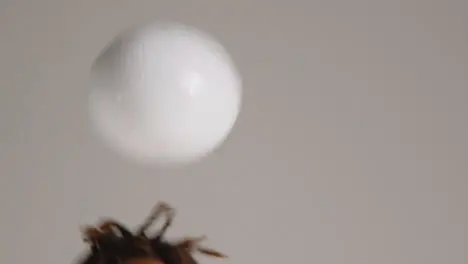 Close Up Of Young Male Footballer In Studio Running and Heading Ball 