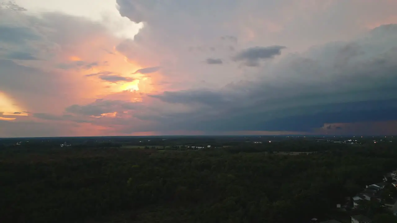 Orange Peach Sunset Clouds With Pan Right Reveal To Thunderstorm Flashes In Large Storm Clouds Over Stittsville