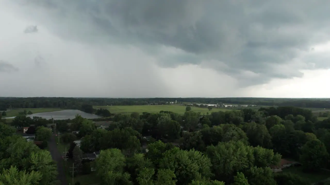 An aerial shot of cloudy sky with rare dark gray clouds with threat of rain over the beautiful meadow