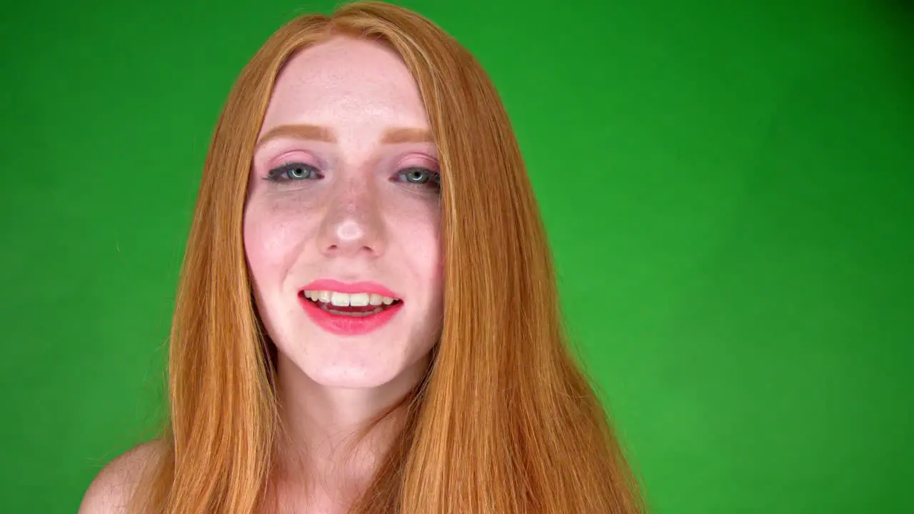 A close up portrait of a beautiful young white woman smiling and looking straight into camera