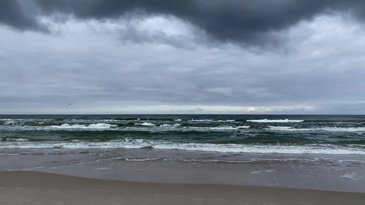 Dark storm clouds over the sea and sandy beach wide shot