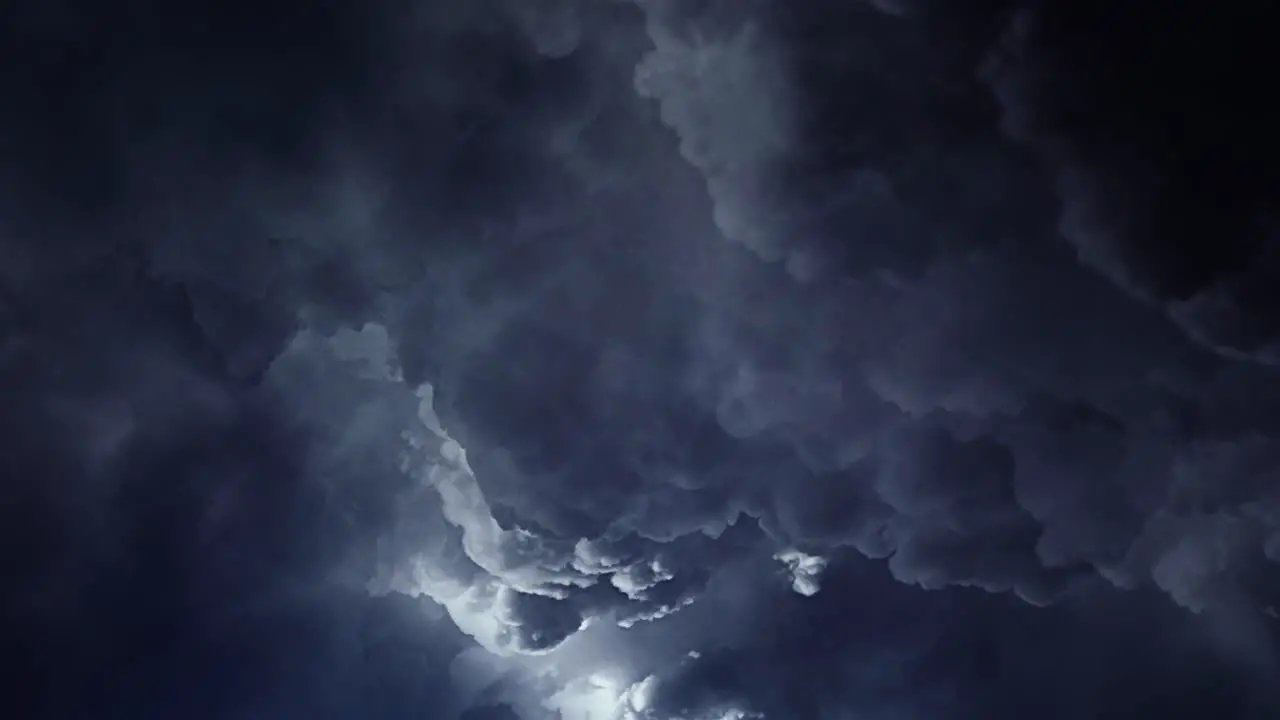 4k view of thunderstorm a ray of light inside a dark gray cloud in the sky that moves