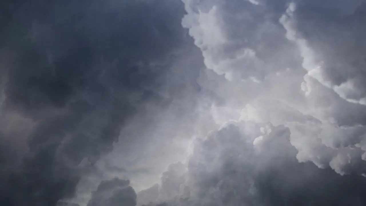 View of thunderstorm dark cloud clumps with lightning flashes