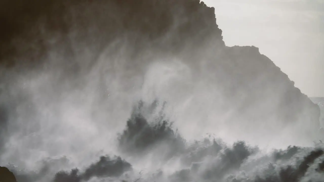 Huge ocean waves roll into a rocky shore in slow motion 1