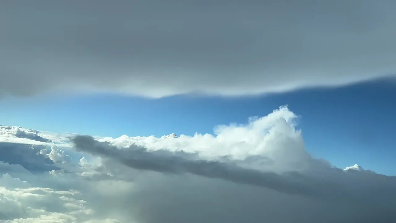 Unique pilot point of view from a jet cockpit is a messy sky avoiding bad weather clouds in a left turn